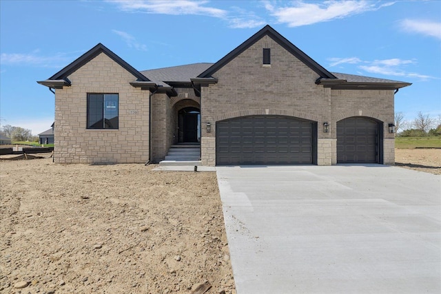 720 Marlayna Dr, Oxford, MI 48371 - french provincial home with a garage, driveway, brick siding, and stone siding