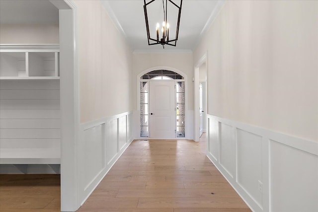 720 Marlayna Dr, Oxford, MI 48371 - interior space featuring an inviting chandelier, light wood-type flooring, a wainscoted wall, and a decorative wall