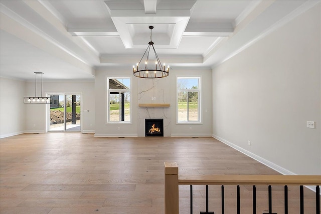 720 Marlayna Dr, Oxford, MI 48371 - unfurnished living room featuring light wood-style floors, a chandelier, baseboards, beamed ceiling, and coffered ceiling