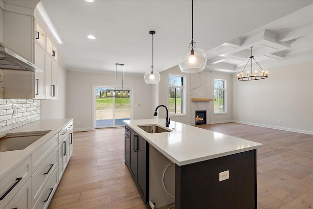 720 Marlayna Dr, Oxford, MI 48371 - kitchen featuring a fireplace, light wood-type flooring, a sink, a chandelier, and recessed lighting