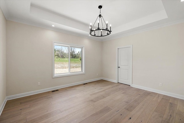 720 Marlayna Dr, Oxford, MI 48371 - spare room featuring a raised ceiling, baseboards, light wood-style flooring, and a chandelier