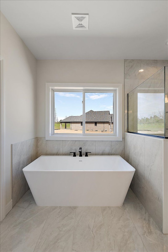 720 Marlayna Dr, Oxford, MI 48371 - bathroom featuring a freestanding tub, visible vents, and marble finish floor