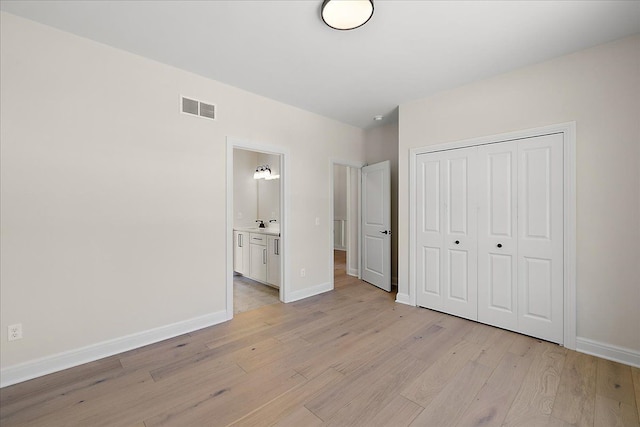 720 Marlayna Dr, Oxford, MI 48371 - unfurnished bedroom with visible vents, light wood-type flooring, baseboards, a closet, and ensuite bathroom