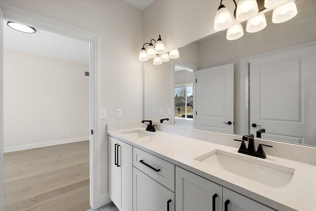 720 Marlayna Dr, Oxford, MI 48371 - full bathroom featuring double vanity, baseboards, a sink, and wood finished floors