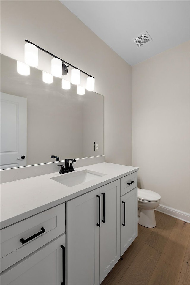 720 Marlayna Dr, Oxford, MI 48371 - bathroom featuring vanity, toilet, baseboards, wood finished floors, and visible vents