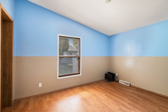 8239 Vanadia Dr, Mount Morris, MI 48458 - spare room with baseboards, vaulted ceiling, wood finished floors, and visible vents