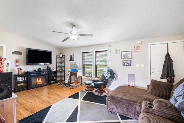 8239 Vanadia Dr, Mount Morris, MI 48458 - living room with a textured ceiling, ceiling fan, wood finished floors, and a glass covered fireplace