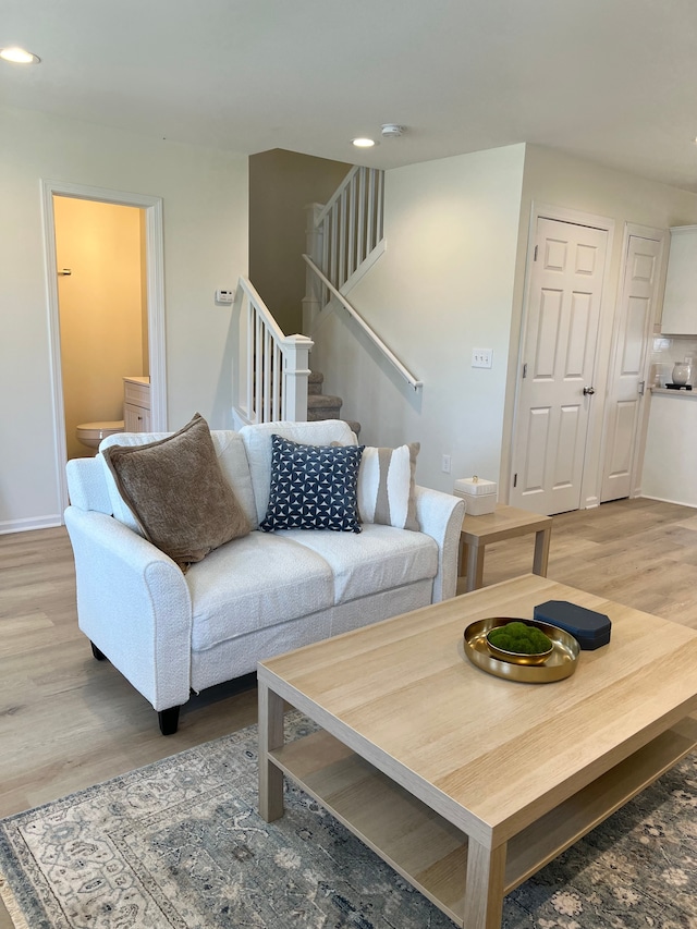 living area with baseboards, recessed lighting, wood finished floors, and stairs