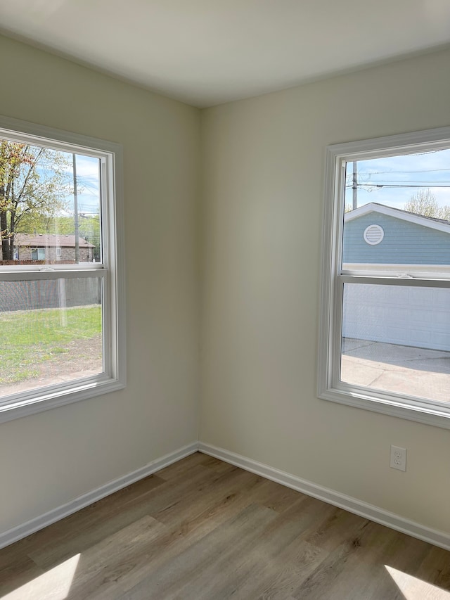 unfurnished room with baseboards and wood finished floors