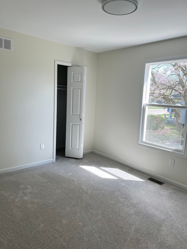 unfurnished bedroom featuring carpet floors, baseboards, and visible vents