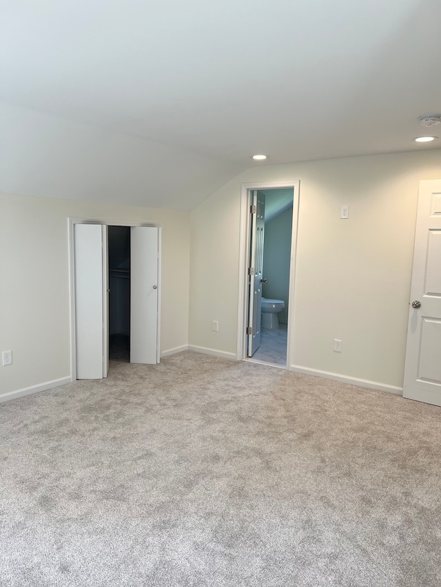 unfurnished bedroom featuring baseboards, light carpet, recessed lighting, and ensuite bath