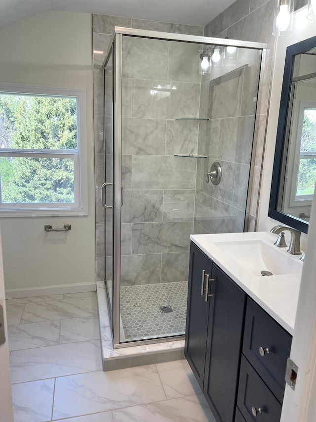 full bathroom featuring vanity, baseboards, marble finish floor, and a stall shower