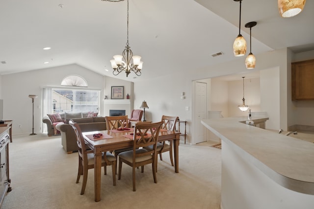 dining space featuring visible vents, a fireplace, vaulted ceiling, and light carpet