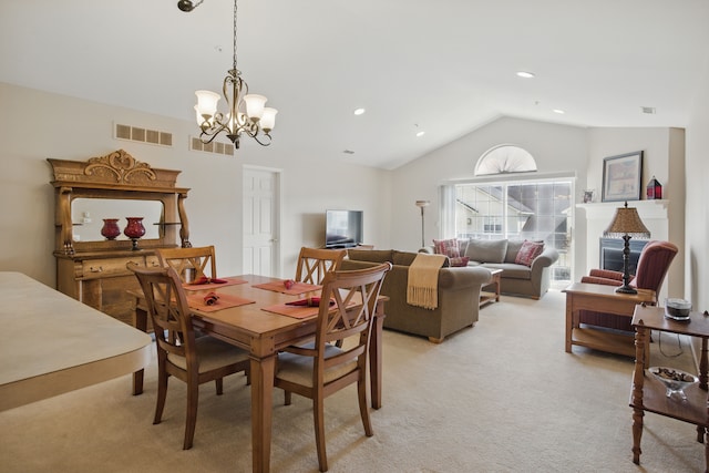 dining area featuring visible vents, a chandelier, vaulted ceiling, and light colored carpet