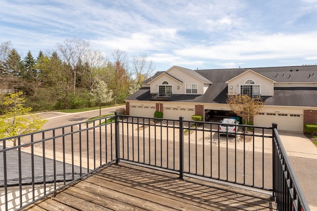 wooden deck with a garage and driveway