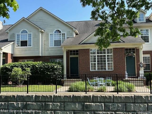 35202 Emma Cir, Walled Lake, MI 48390 - view of front of house with a fenced front yard and brick siding