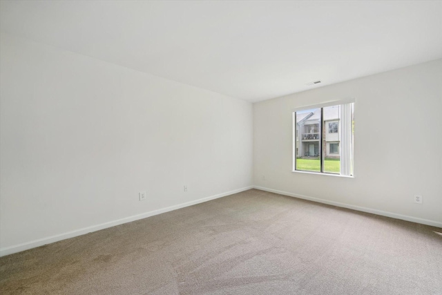 unfurnished room with visible vents, baseboards, and carpet floors