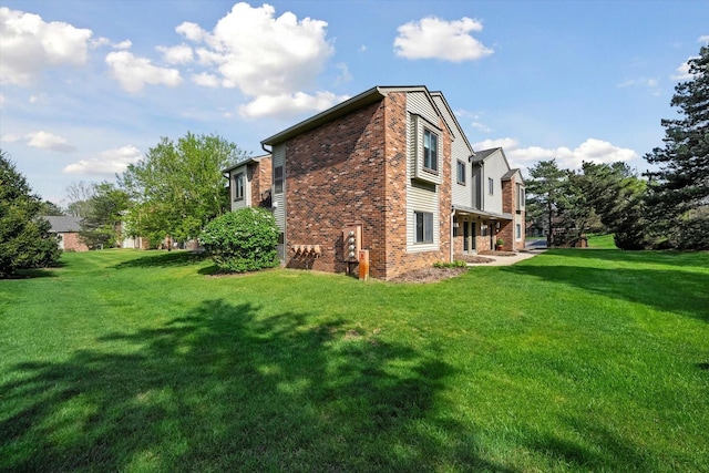 view of side of home with brick siding and a lawn