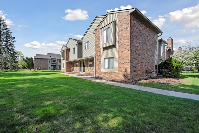 exterior space with brick siding and a lawn