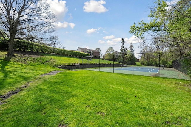 exterior space with a yard, a tennis court, and fence