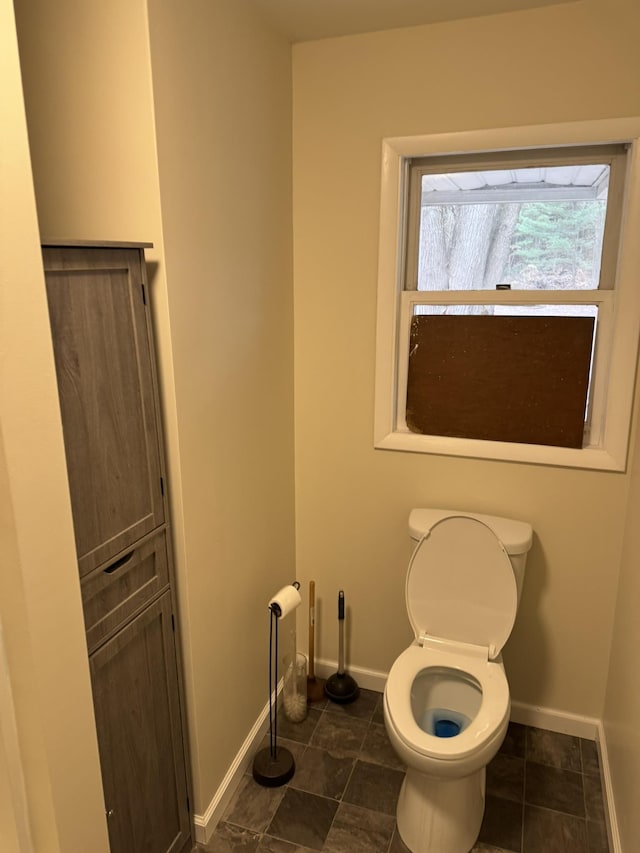 8854 E Pickard Rd, Mount Pleasant, MI 48858 - bathroom featuring baseboards and toilet