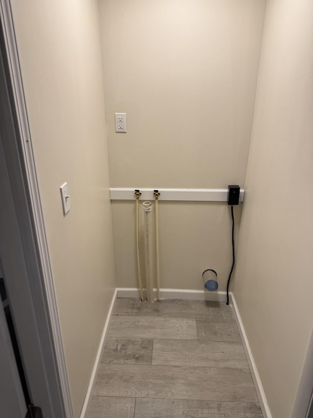 8854 E Pickard Rd, Mount Pleasant, MI 48858 - laundry area with baseboards, laundry area, and wood finished floors