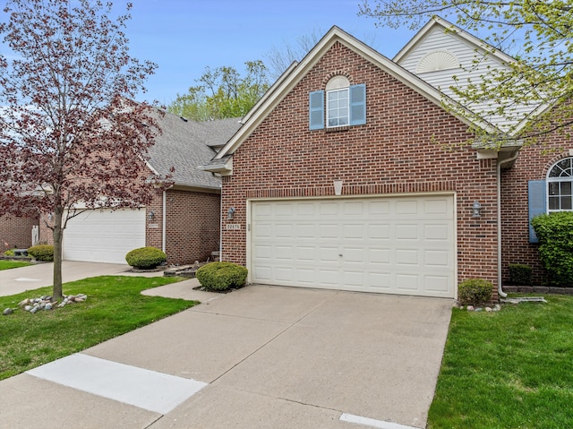 traditional-style home featuring a garage, concrete driveway, a front yard, and brick siding