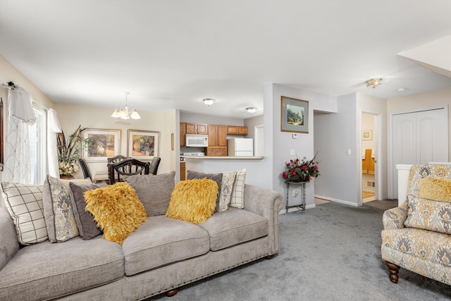 carpeted living room featuring baseboards and a chandelier
