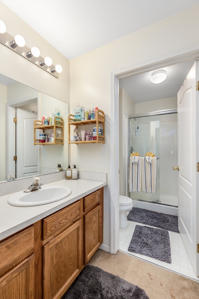 full bathroom with vanity, a stall shower, and toilet
