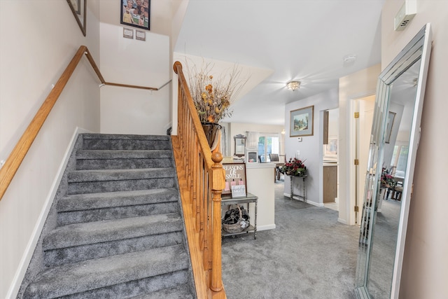 stairway featuring baseboards and carpet