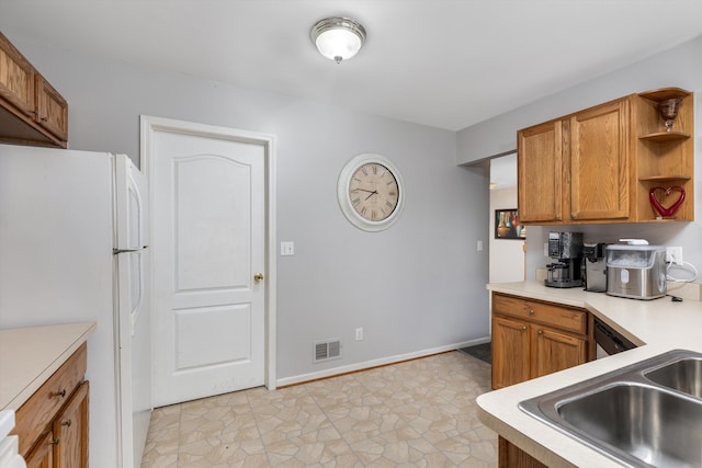 kitchen with open shelves, light countertops, brown cabinetry, freestanding refrigerator, and visible vents