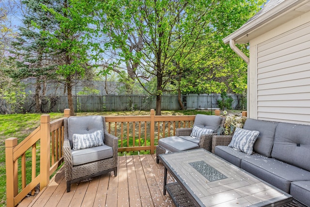 wooden deck with a fenced backyard and an outdoor living space with a fire pit