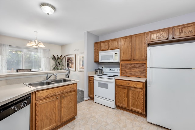 kitchen with white appliances, a chandelier, a sink, and light countertops