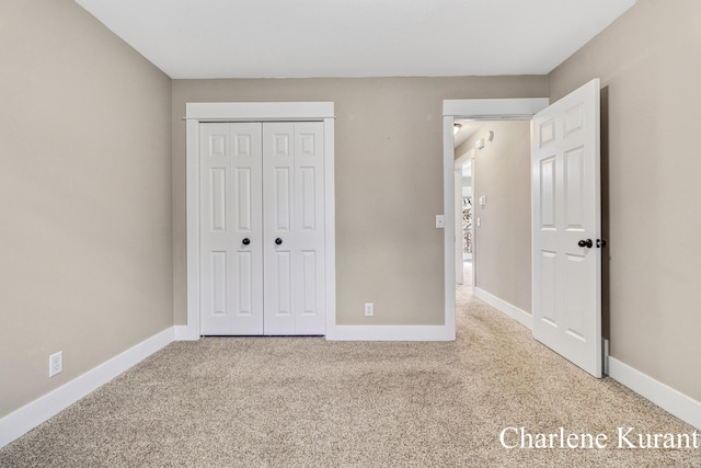 unfurnished bedroom featuring baseboards, carpet, and a closet