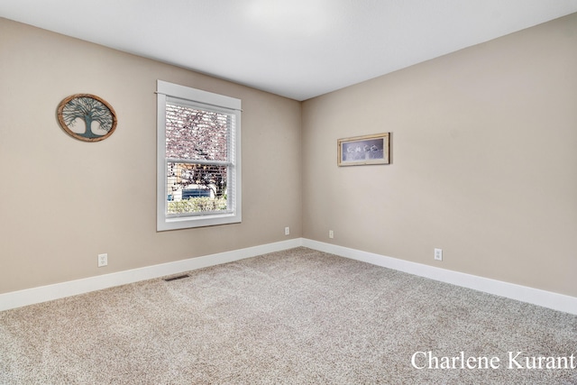 spare room with baseboards, carpet flooring, and visible vents
