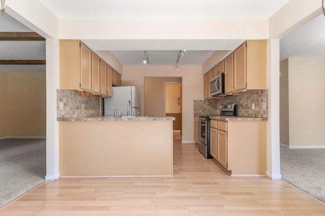 6360 Robison Ln, Saline, MI 48176 - kitchen featuring light countertops, appliances with stainless steel finishes, decorative backsplash, and light wood-style flooring