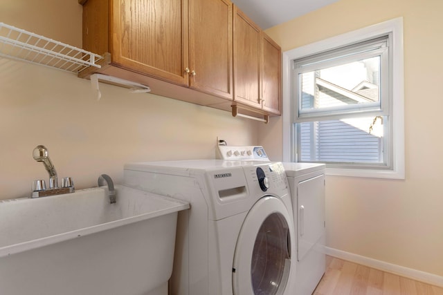 6360 Robison Ln, Saline, MI 48176 - washroom featuring baseboards, light wood-type flooring, washer and clothes dryer, a sink, and cabinet space