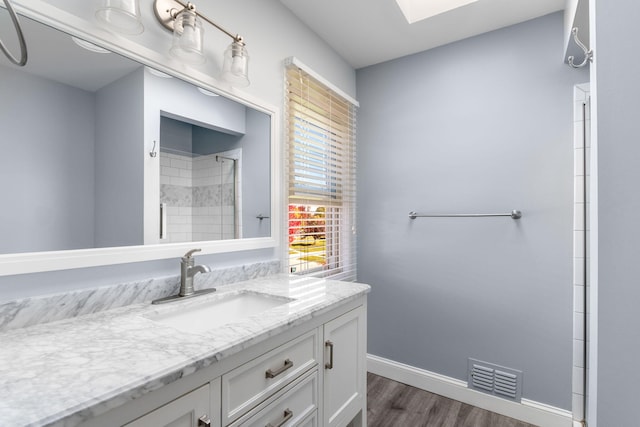 6360 Robison Ln, Saline, MI 48176 - bathroom featuring baseboards, wood finished floors, a skylight, visible vents, and tiled shower