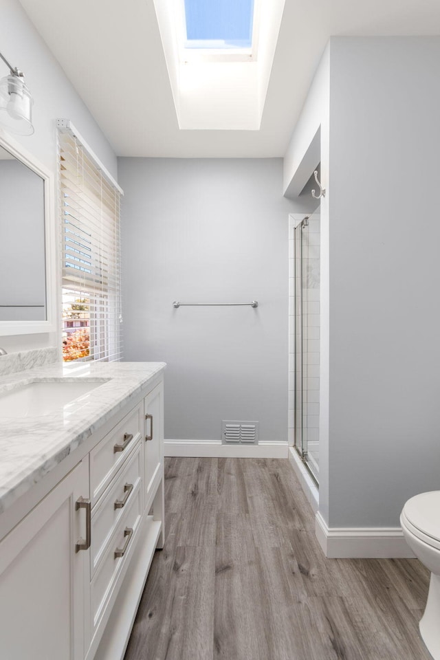 6360 Robison Ln, Saline, MI 48176 - bathroom featuring visible vents, a shower with shower door, wood finished floors, vanity, and toilet