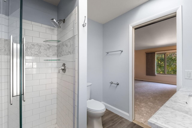 6360 Robison Ln, Saline, MI 48176 - bathroom featuring toilet, baseboards, a shower stall, and wood finished floors