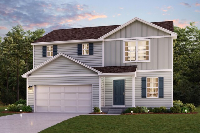 traditional-style house featuring driveway, a shingled roof, board and batten siding, an attached garage, and a yard
