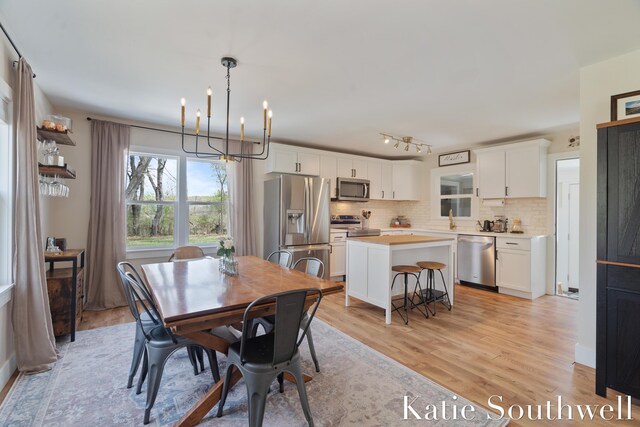 dining area featuring an inviting chandelier and light wood-style flooring