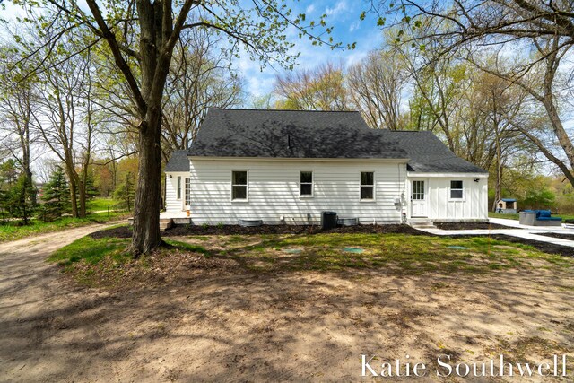 back of house with entry steps and a shingled roof