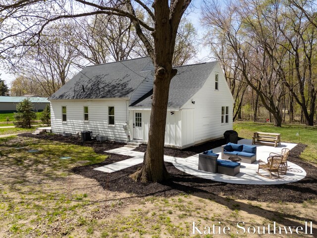 back of property with an outdoor hangout area, a shingled roof, central AC unit, a patio area, and entry steps