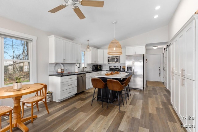 kitchen featuring appliances with stainless steel finishes, decorative backsplash, a sink, and plenty of natural light