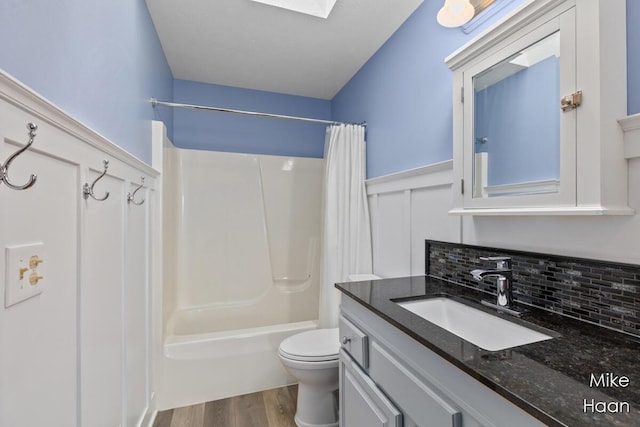 full bathroom featuring vanity, decorative backsplash, wood finished floors, toilet, and shower / bathtub combination with curtain