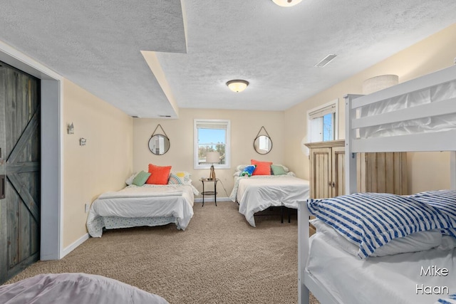 carpeted bedroom featuring baseboards and a textured ceiling