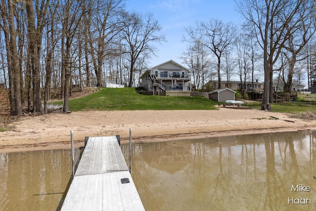 view of dock with a water view and a yard
