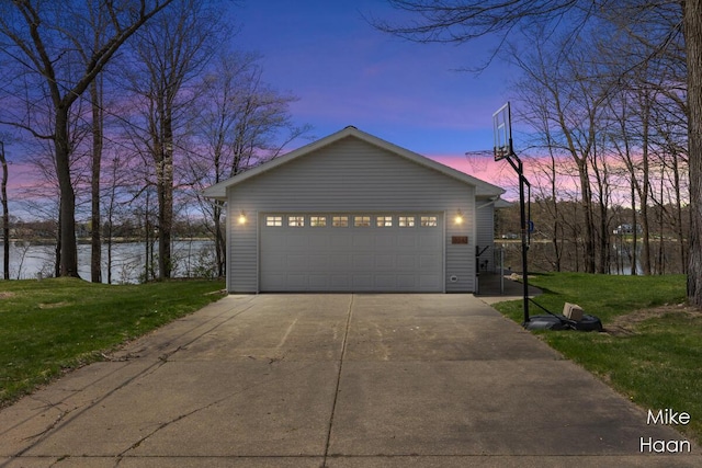 view of front of property featuring a detached garage, a water view, and a front lawn