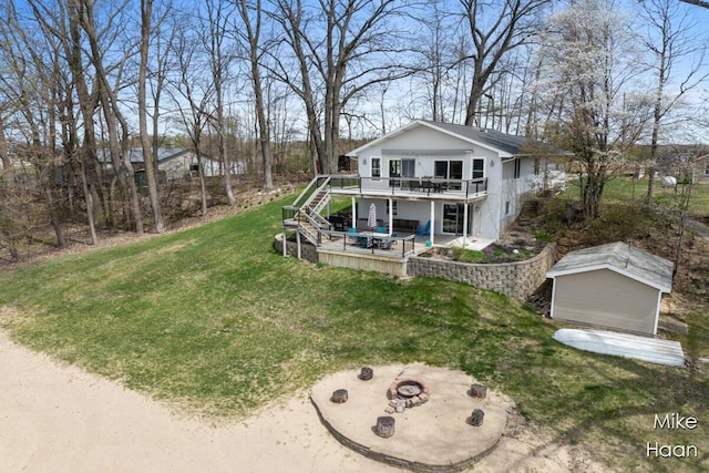 view of front facade with a wooden deck, a front lawn, a patio, a fire pit, and stairs